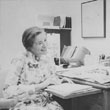 Barb Cook at desk with student, photo taken in 1960s